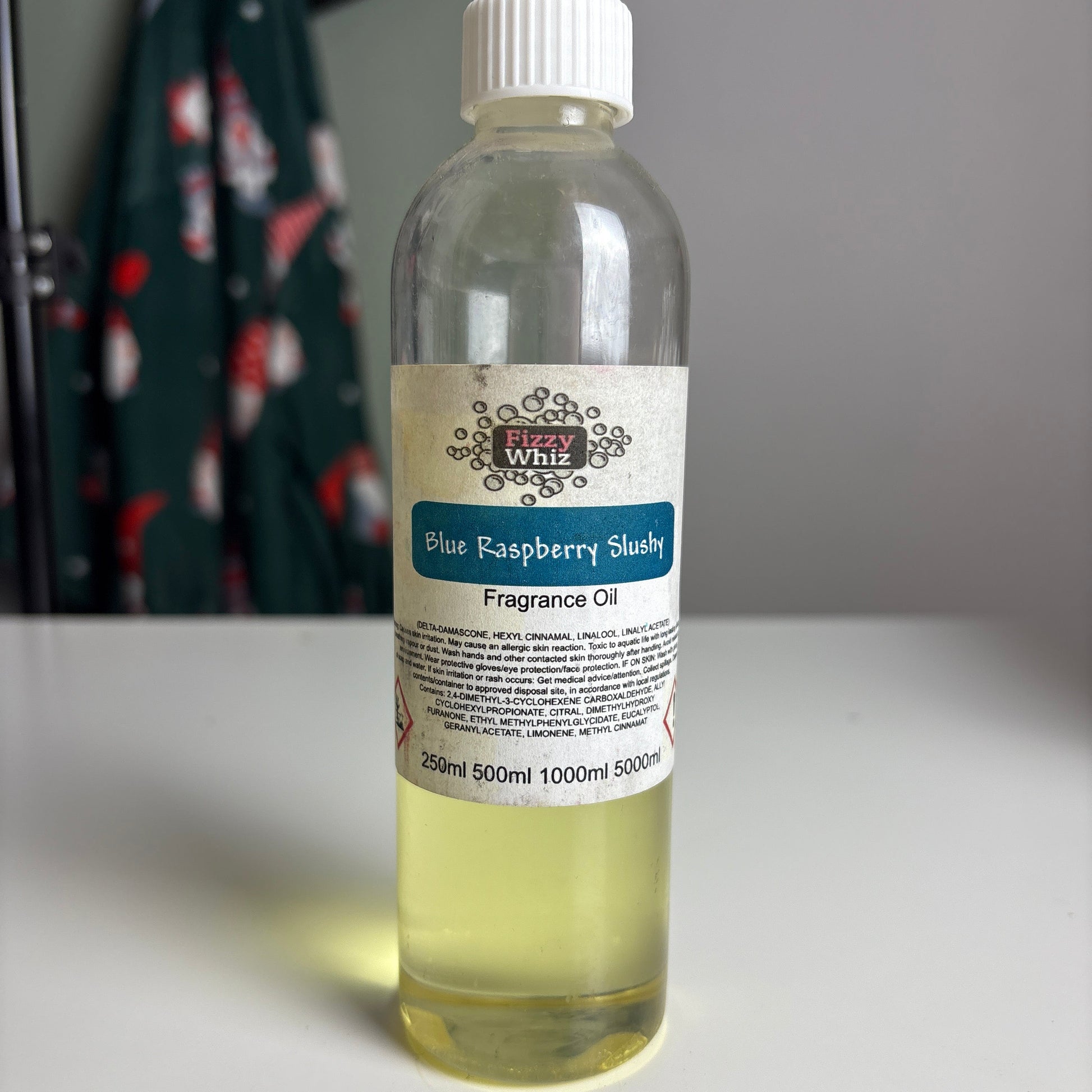 Small bottle of blue raspberry flavoring oil with a label on a blurred background